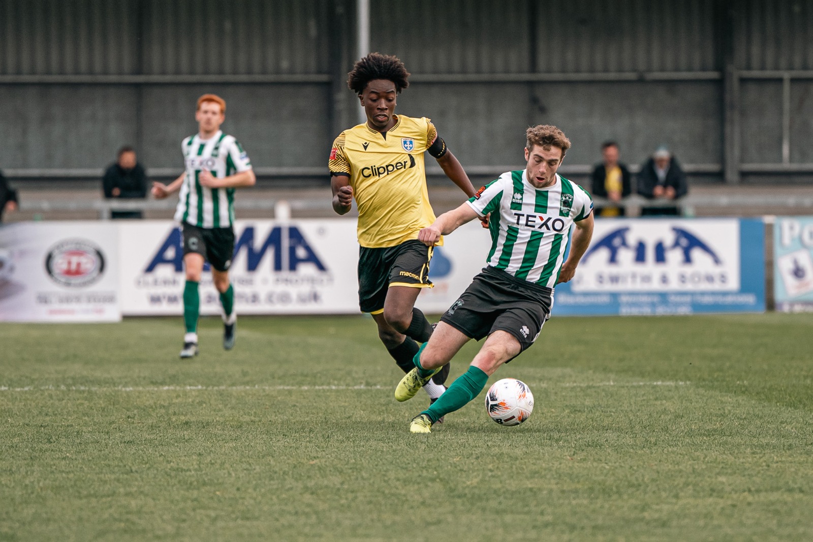 Foley playing in a yellow Guiseley kit during a match