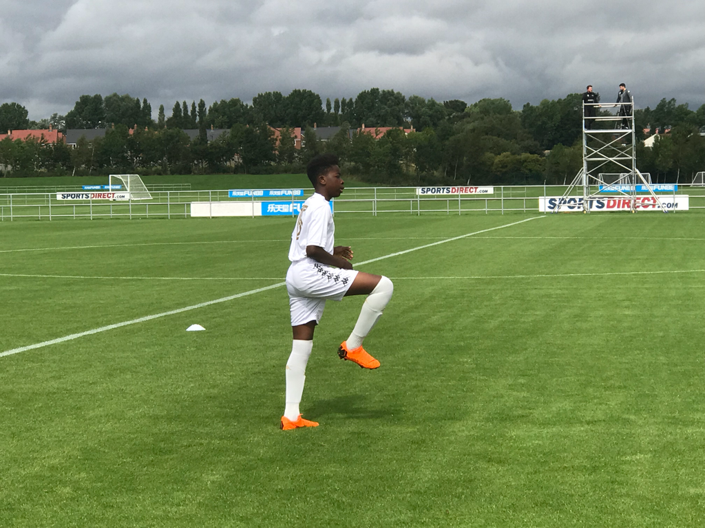 Foley warming up on a football pitch in a white kit